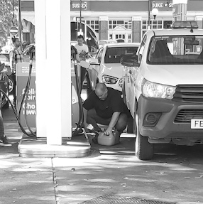 motorist filling up jerrycan at the pumps